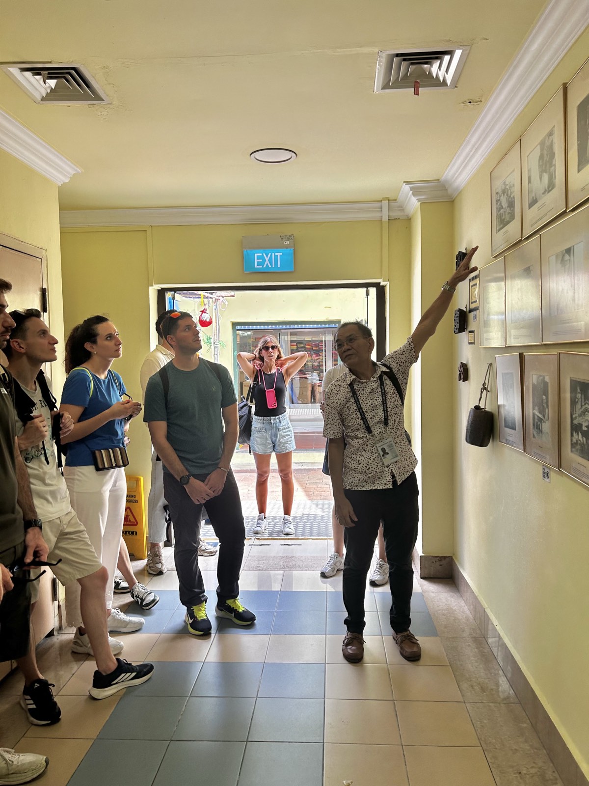Michael Tan explaining museum exhibits to a walking tour group